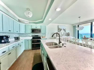 a kitchen with blue cabinets and a sink at Pelican Walk 206 in Panama City Beach