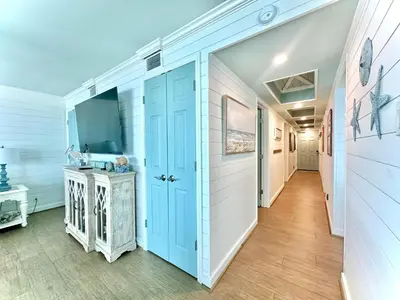 a hallway with a blue door in a house at Pelican Walk 206 in Panama City Beach