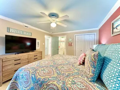 a bedroom with a bed and a flat screen tv at Pelican Walk 206 in Panama City Beach