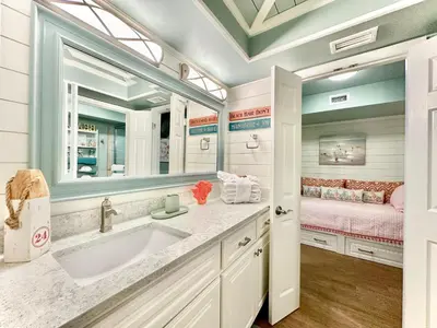 a bathroom with a sink and a bed at Pelican Walk 206 in Panama City Beach