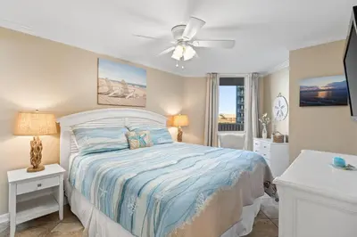 a bedroom with a bed and a ceiling fan at Pelican Walk 510 in Panama City Beach