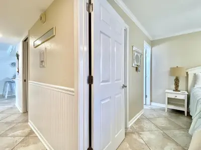 a hallway with a white door and a bedroom at Pelican Walk 510 in Panama City Beach