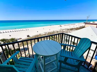 a table and chairs on a balcony with a beach at Pelican Walk 510 in Panama City Beach