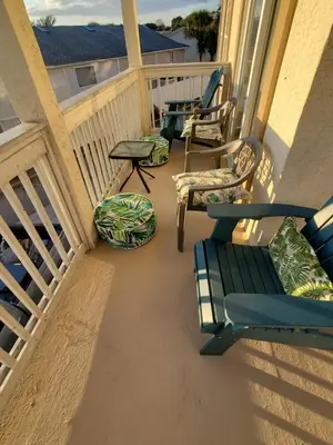 a balcony with chairs and a table and a table at Coastal Castaway-Beach Retreat-Steps 2 Sand-Sleep 10-Pool-Hot tub in Panama City Beach