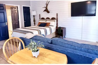 a living room with a blue couch and a bed at Coastal Castaway-Beach Retreat-Steps 2 Sand-Sleep 10-Pool-Hot tub in Panama City Beach