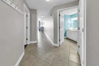 a hallway of a bathroom with a sink and a mirror at Tidewater 1916 in Panama City Beach