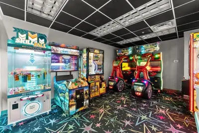 a room with arcade games and video game machines at Tidewater 1916 in Panama City Beach