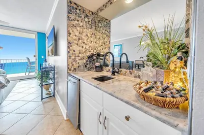 a kitchen with a sink and a counter with a basket of food at Majestic Beach Towers 2-404 in Panama City Beach