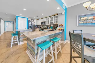 a kitchen with a large bar with blue accents at Majestic Beach Towers 2-404 in Panama City Beach