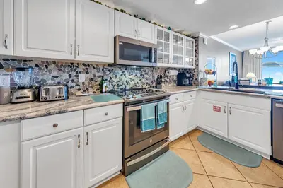 a kitchen with white cabinets and a stove top oven at Majestic Beach Towers 2-404 in Panama City Beach