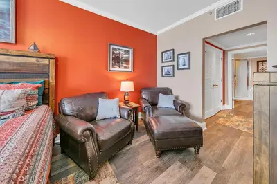 a bedroom with two chairs and a bed and orange walls at Majestic Beach Towers 2-404 in Panama City Beach