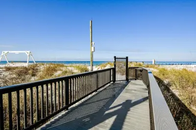 a wooden walkway to the beach with the ocean in the background at Sunbird Beach Resort 1011W By Book That Condo in Panama City Beach