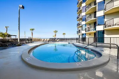 a swimming pool in front of a apartment building at Sunbird Beach Resort 1011W By Book That Condo in Panama City Beach