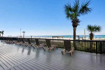 a row of chairs on a boardwalk next to the beach at Sunbird Beach Resort 1011W By Book That Condo in Panama City Beach