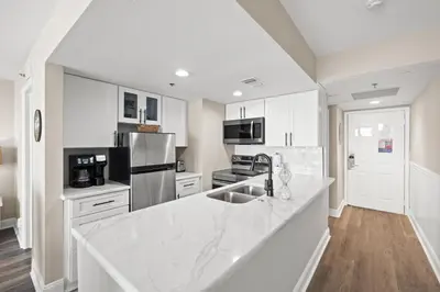 a kitchen with white cabinets and a white counter top at Sunbird Beach Resort 1011W By Book That Condo in Panama City Beach