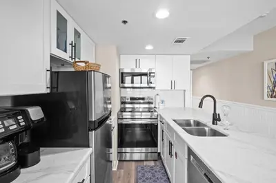 a kitchen with a sink and a refrigerator at Sunbird Beach Resort 1011W By Book That Condo in Panama City Beach