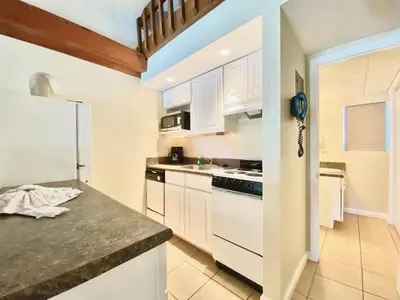 a kitchen with white cabinets and a white refrigerator at Casa Blanca Resort Studio Loft in Panama City Beach