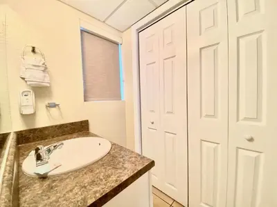 a bathroom with a sink and a white door at Casa Blanca Resort Studio Loft in Panama City Beach