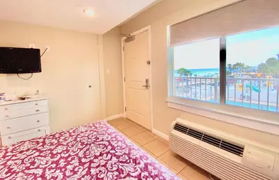 a bedroom with a large window with a view of the ocean at Casa Blanca Resort Studio Loft in Panama City Beach
