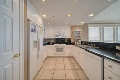 a kitchen with white cabinets and a sink at Treasure Island 0901 in Panama City Beach