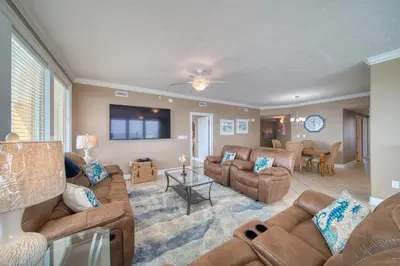 a living room with couches and a dining room at Treasure Island 0901 in Panama City Beach