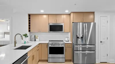 a kitchen with stainless steel appliances and wooden cabinets at Treasure Island 1405 in Panama City Beach