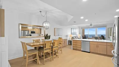 a kitchen and dining room with a table and chairs at Treasure Island 1405 in Panama City Beach