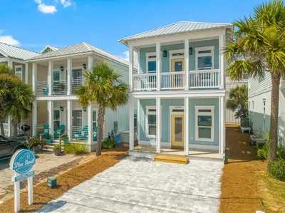 a large house with palm trees in front of it at 22704 Front Beach Road | Ocean Breeze in Panama City Beach