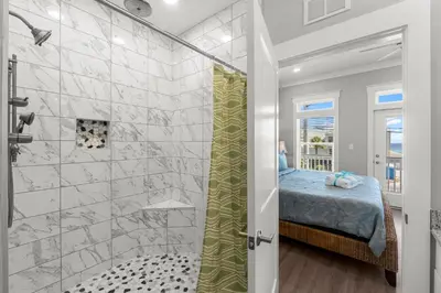 a master bathroom with a shower and a bed at 22704 Front Beach Road | Ocean Breeze in Panama City Beach