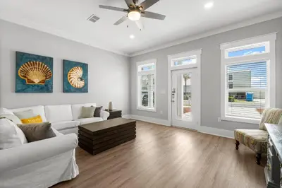 a living room with white furniture and a ceiling fan at 22704 Front Beach Road | Ocean Breeze in Panama City Beach