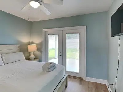 a bedroom with a white bed and a window at PC Beach Retreat A in Panama City Beach
