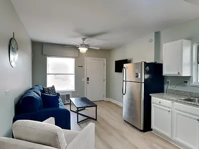 a kitchen with a blue couch and a refrigerator at PC Beach Retreat A in Panama City Beach