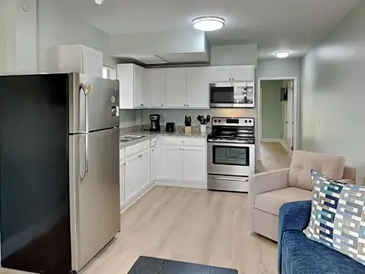 a kitchen with a stainless steel refrigerator and a couch at PC Beach Retreat A in Panama City Beach