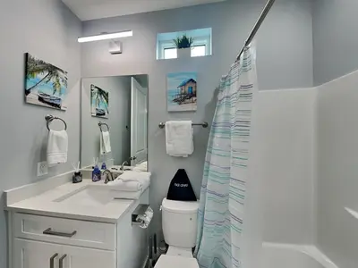 a bathroom with a sink and a toilet and a mirror at Ocean Pearl Villa in Panama City Beach