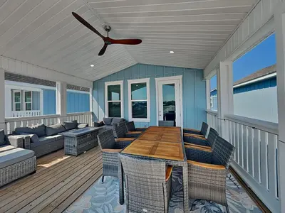 a screened porch with a wooden table and chairs at Ocean Pearl Villa in Panama City Beach