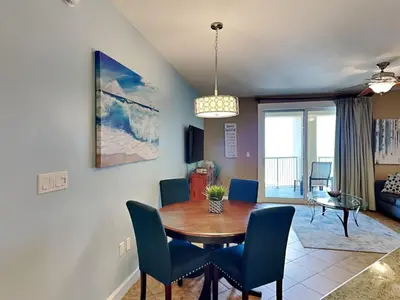a dining room and living room with a table and chairs at Grand Panama Beach Resort - The Grand II #803 in Panama City Beach
