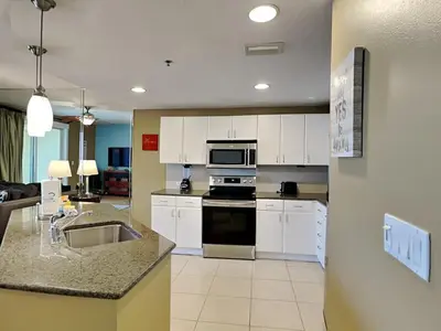 a kitchen with white cabinets and a stove top oven at Grand Panama Beach Resort - The Grand II #803 in Panama City Beach