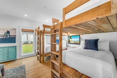 a bedroom with a bunk bed and a desk and a window at No Ragrets in Inlet Beach