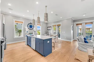 an open kitchen and living room with a blue island at No Ragrets in Inlet Beach