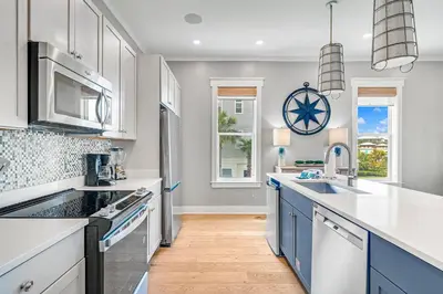 a kitchen with white cabinets and blue appliances at No Ragrets in Inlet Beach