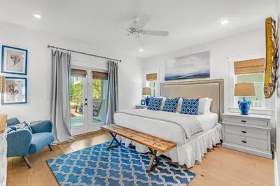 a bedroom with a bed and a blue rug at No Ragrets in Inlet Beach