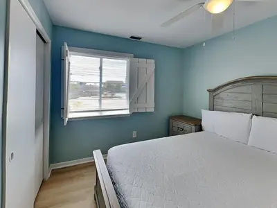 a bedroom with a large bed and a window at PC Beach Retreat C in Panama City Beach