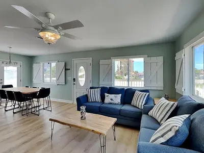 a living room with a blue couch and a table at PC Beach Retreat C in Panama City Beach