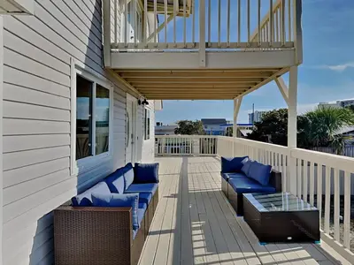 a porch with blue chairs and a balcony at PC Beach Retreat C in Panama City Beach