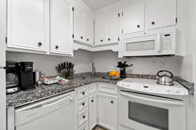 a kitchen with white cabinets and white appliances at Renovated Townhome 5 mins walk to Beach, in the best resort in PCB, Horizon South in Panama City Beach