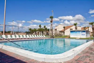 a large swimming pool with chairs around it at Renovated Townhome 5 mins walk to Beach, in the best resort in PCB, Horizon South in Panama City Beach