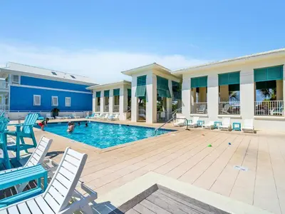 a swimming pool with chairs and people in a building at Relax Awhile - Carriage House in Panama City Beach
