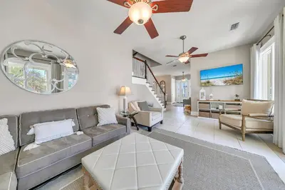 a living room with a couch and a ceiling fan at Relax Awhile - Main House in Panama City Beach