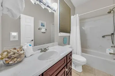 a white bathroom with a sink and a toilet at Relax Awhile - Main House in Panama City Beach
