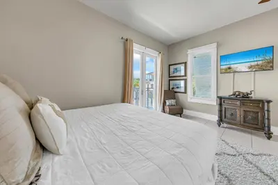 a white bedroom with a bed and a window at Relax Awhile - Main House in Panama City Beach